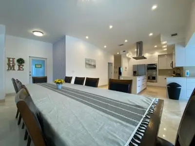 a large room with a large table with chairs and a kitchen at Pool Villa in Miami