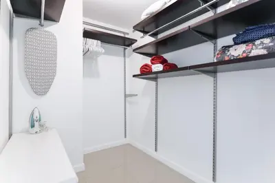 a walk in closet with white walls and black shelves at Relax Family Midtown - free parking & Great pool in Miami