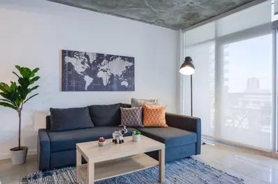 a living room with a blue couch and a coffee table at Relax Family Midtown - free parking & Great pool in Miami