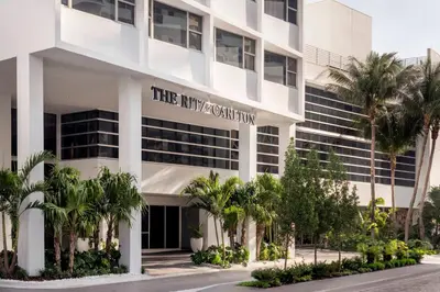 a large white building with palm trees in front of it at The Ritz-Carlton, South Beach in Miami Beach