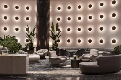 a lobby with couches chairs and tables in a building at The Ritz-Carlton, South Beach in Miami Beach