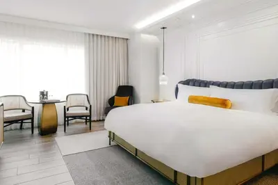 a bedroom with a large bed and a dining room at The Ritz-Carlton, South Beach in Miami Beach
