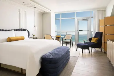 a hotel room with a bed and a view of the ocean at The Ritz-Carlton, South Beach in Miami Beach