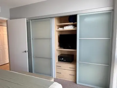 a bedroom with a closet with a tv and a bed at MVR Apartments at Marenas in Miami Beach