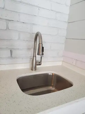 a stainless steel sink in a kitchen counter at Hollywood Gardens Inn & Suites in Hollywood