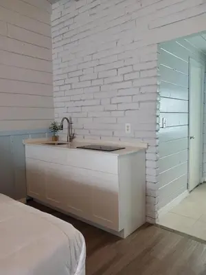 a kitchen with a sink and a brick wall at Hollywood Gardens Inn & Suites in Hollywood