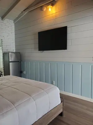 a bedroom with a bed and a flat screen tv on the wall at Hollywood Gardens Inn & Suites in Hollywood