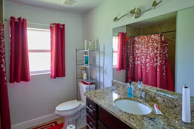 a bathroom with a sink and a red shower curtain at Fabulous Hollywood Living Space in Hollywood