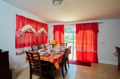a dining room with a table with red curtains at Fabulous Hollywood Living Space in Hollywood
