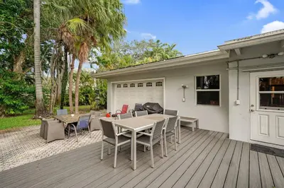 a patio with a table and chairs on a deck at Large home wking bed by PMI unit BH in Fort Lauderdale