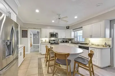 a kitchen with white cabinets and a table and chairs at Large home wking bed by PMI unit BH in Fort Lauderdale