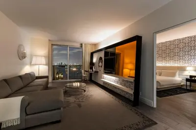 a living room with a couch and a bed and a large window at Mondrian South Beach in Miami Beach