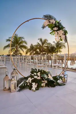 a wedding arch with flowers and lights on a patio at Mondrian South Beach in Miami Beach