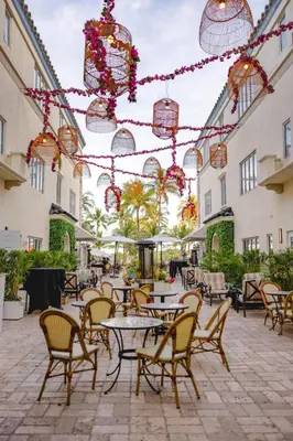 an outdoor patio with tables and chairs and lights at Hotel Ocean in Miami Beach