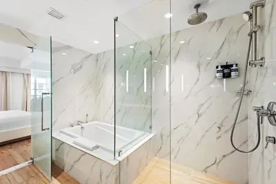 a bathroom with a tub and a glass shower stall at Hotel Ocean in Miami Beach