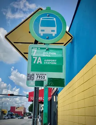 a street sign with a bus on it next to a building at Cozy Private House near Miami Airport - Free parking - 01 in Miami