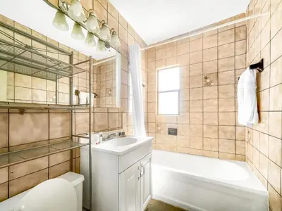 a bathroom with a sink and a tub and a toilet at Neptune Oceanfront Rentals in Hollywood