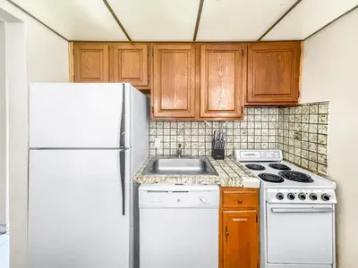 a kitchen with white appliances and wooden cabinets at Neptune Oceanfront Rentals in Hollywood
