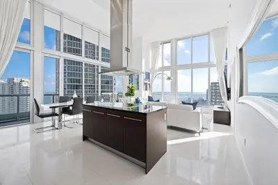 a kitchen with a table and chairs and large windows at ICONIC LUXURIOUS HIGH CEILINGS UNIT BRICKELL w in Miami