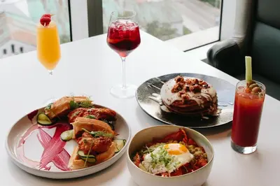 a table with plates of food and a glass of juice at Splendid Unit outstanding View-W Hotel Brickell in Miami