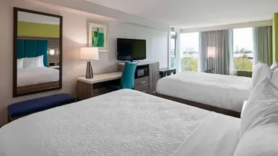 a hotel room with two beds and a mirror at Best Western Plus Oceanside Inn in Fort Lauderdale