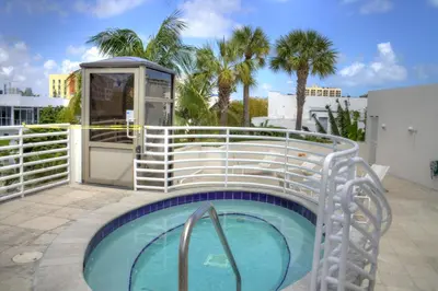 a small swimming pool with a fence and a building at Dream Destinations at Ocean Place in Miami Beach