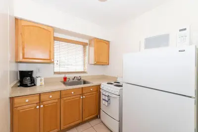 a kitchen with a white refrigerator and a sink at Tropic Isle Hotel & Apartment in Hollywood