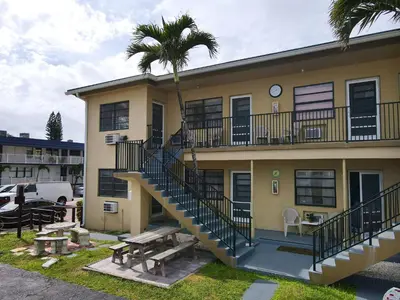 a building with stairs and a picnic table in front of it at Tropic Isle Hotel & Apartment in Hollywood