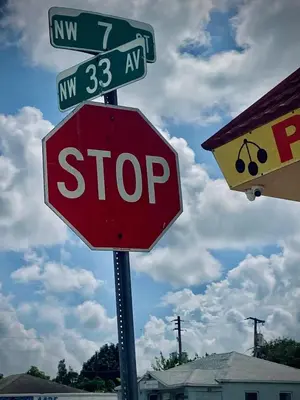 a stop sign with street signs on top of it at Pretty Private Room, near the Airport - Free parking - 01 in Miami