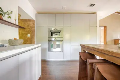 a kitchen with white cabinets and a wooden counter top at Casa Ishi - at lumicollection in Miami