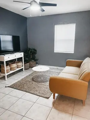 a living room with a couch and a tv at Lovely Bohemian Apartment in Fort Lauderdale