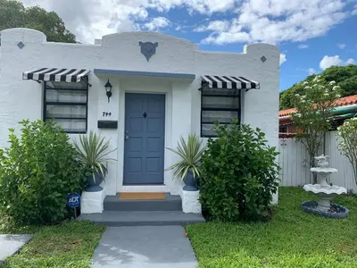 a white house with a blue door at Cozy Private Room, near the Airport - Free parking - 01 in Miami