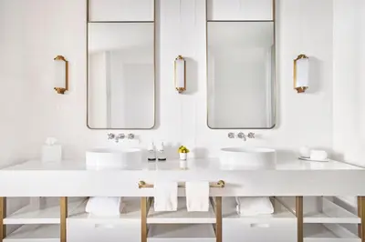 a white bathroom with two sinks and mirrors at Four Seasons Hotel and Residences Fort Lauderdale in Fort Lauderdale