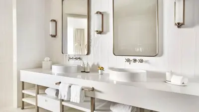 a white bathroom with two sinks and a mirror at Four Seasons Hotel and Residences Fort Lauderdale in Fort Lauderdale