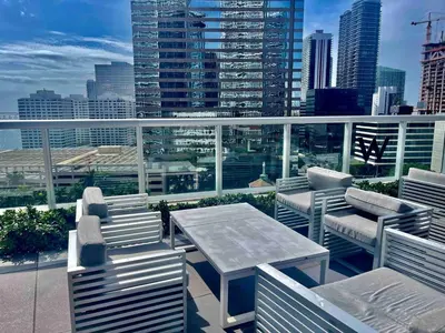 a balcony with a table and chairs and a view of a city at Sun&Sea IconBrickell Unit in Miami