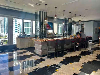 a restaurant with a bar with people sitting at it at Sun&Sea IconBrickell Unit in Miami