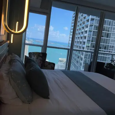 a bedroom with a bed and a large window at Sun&Sea IconBrickell Unit in Miami