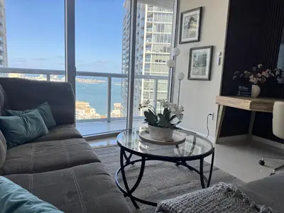 a living room with a couch and a glass table at Sun&Sea IconBrickell Unit in Miami