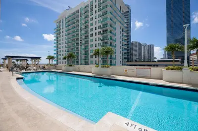 a large swimming pool in front of a tall building at LUXURY 3 Bedrooms BRICKELL BAY APARTMENT in Miami