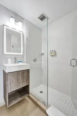 a white bathroom with a shower and a sink at Hotel Sheldon in Hollywood