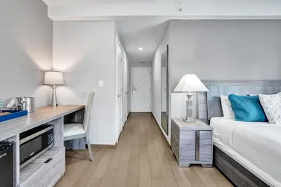 a hotel room with a bed and a desk with a television at Hotel Sheldon in Hollywood