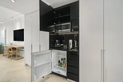 a kitchen with black cabinets and an open refrigerator at W SOUTH BEACH Residences Private King Studio in Miami Beach