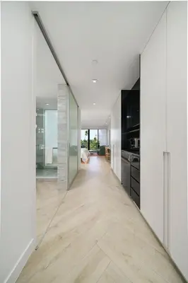 a hallway of a kitchen with white walls and wood floors at W SOUTH BEACH Residences Private King Studio in Miami Beach