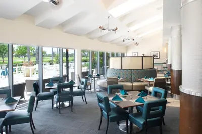 a dining room with tables and chairs and windows at Sheraton Miami Airport Hotel and Executive Meeting Center in Miami