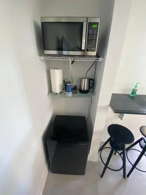 a kitchen with a microwave and a table and chairs at LYZ Miami in Miami