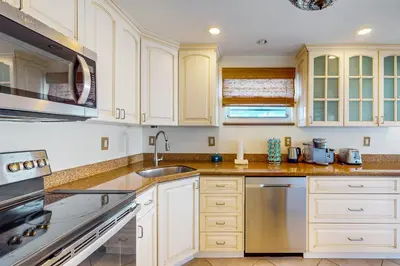 a kitchen with white cabinets and a sink at Samira's South Beach Paradise in Miami Beach