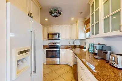a large kitchen with white cabinets and appliances at Samira's South Beach Paradise in Miami Beach