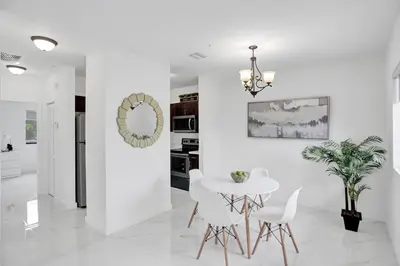 a white dining room with a white table and chairs at Renzzi Wynwood Apartments in Miami