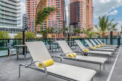 a row of chairs and tables on a balcony with buildings at Cambria Hotel Fort Lauderdale Beach in Fort Lauderdale