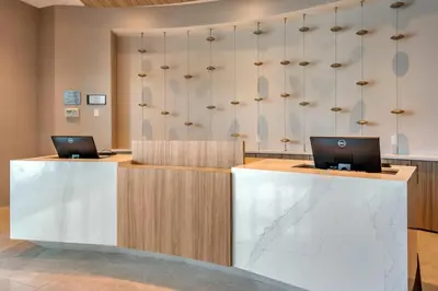 a lobby with two laptops on top of a counter at Cambria Hotel Fort Lauderdale Beach in Fort Lauderdale